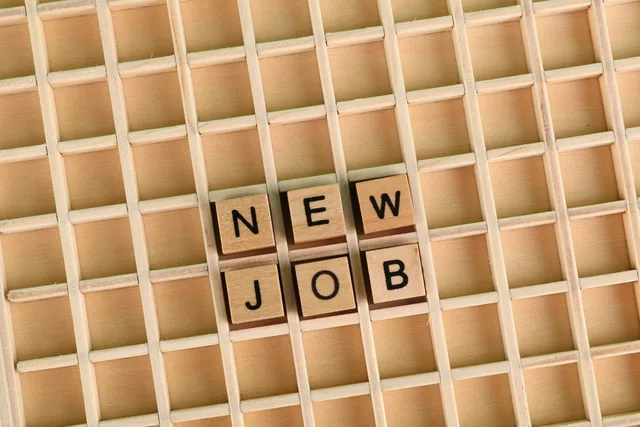 Discover the excitement of a new job with wooden letter tiles spelling 'NEW JOB' on a grid. Separating competitor, employment and support queries